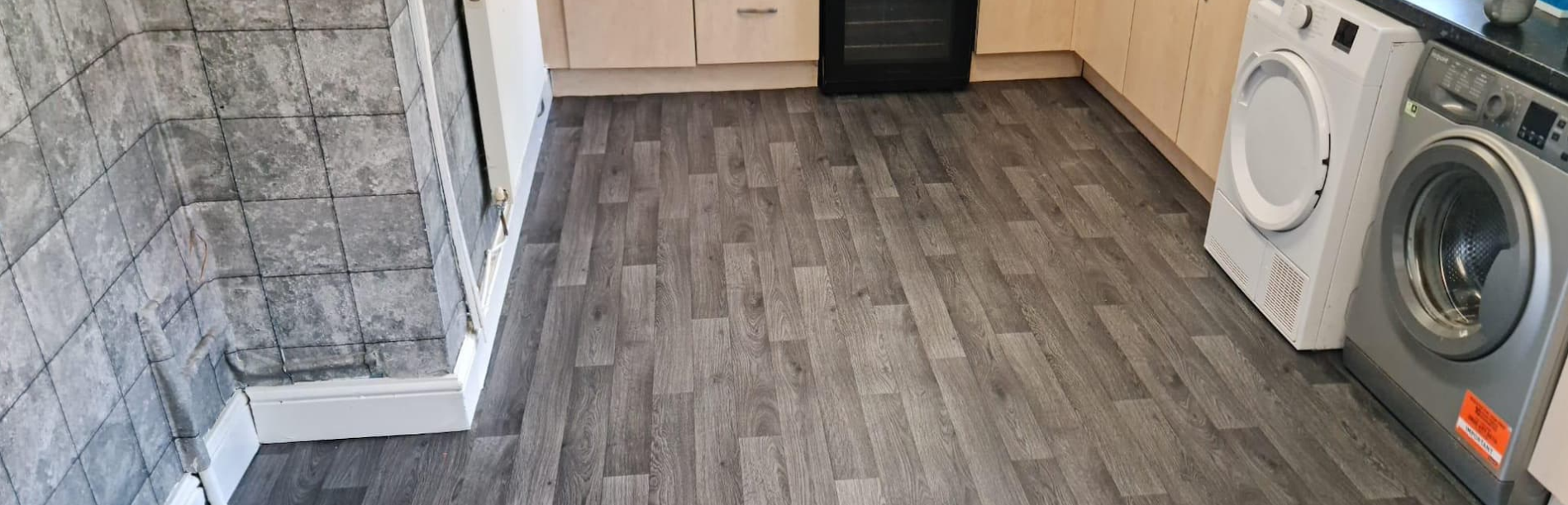 Grey laminate flooring in a kitchen and utility area